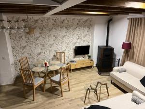 ラ・アルベルカにあるLa casina de la albercaのテーブルと椅子とテレビのあるリビングルーム