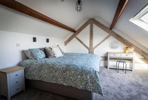 a bedroom with a bed and a desk in a attic at Tractor Shed, seaside cosy cottage for 4 in Beaumaris