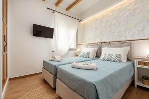 a bedroom with two beds with towels on them at Aethrion Boutique Apartment in Naxos Chora