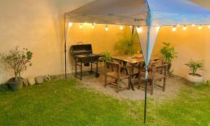 a tent with a table and a grill in a yard at Casa Climatizada Privada con Jardín y BBQ in Ciudad Valles