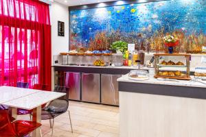 a restaurant with a counter with food on it at Hotel Demo' in Milan