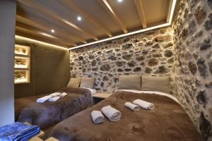 two beds in a room with rocks on the wall at D&P Cell Oneiro. in Kalavrita