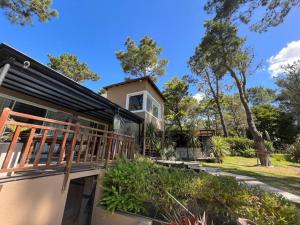 une maison avec une grande terrasse sur le côté dans l'établissement Carilo para 10, frente al golf con Pileta Climatizada!, à Carilo