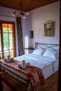 a bedroom with a large bed with white sheets at Vila Elati Oreini Korinthia in Velína