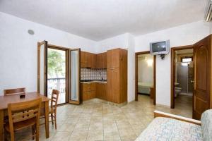 a living room with a dining table and a kitchen at Residence Villa Candida in Vieste