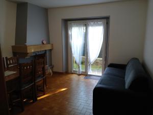 a living room with a couch and a sliding glass door at Agréable appartement de 80M2 dans Maison in Lourdes