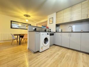 a kitchen with a washing machine and a table at Havre de paix au cœur des vignes pour 4 à 6 personnes in Epfig +16 photos