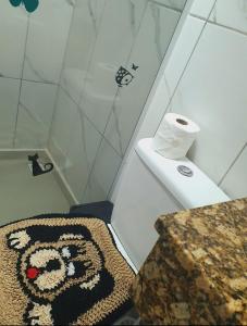a bathroom with a shower with a roll of toilet paper at Cantinho das Palmeiras em Itapoá- Casa c piscina p 6 pessoas in Itapoa