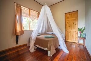 a bedroom with a bed with a mosquito net at Casa Grande at Pacuare Reserve in Matina