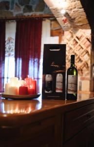 a bottle of wine and candles on a table at Vila Elati Oreini Korinthia in Velína