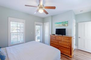 une chambre avec un lit et un ventilateur de plafond dans l'établissement Barefoot Cottages #B22, à Highland View