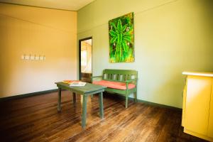 a room with a bench and a table and a painting at Casa Grande at Pacuare Reserve in Matina