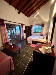 a bedroom with two beds and a table in a room at Reef Bungalow Hotel in Pamunugama +95 photos
