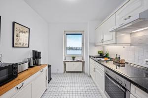 a kitchen with white appliances and a window at Strand-Apartment, Strandkorb, Meeresrauschen, Parkplatz in Wilhelmshaven