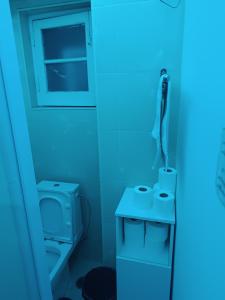 a bathroom with a toilet and a blue light at Sams Rooms - Solo Female Guest House in Amadora