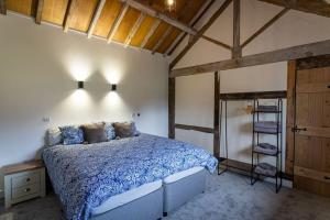 a bedroom with a bed and a wooden ceiling at Long Barn, seaside cosy cottage for 8 in Beaumaris