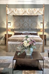 a bedroom with a bed with a vase of flowers on a table at Camillas Hus in Oslo