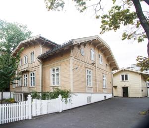 a large wooden house with a white fence at Camillas Hus in Oslo