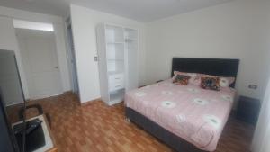 a bedroom with a bed with a pink comforter at Habitaciones en la Casa de Dora, 4to y 5to piso in Ayacucho