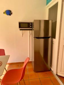 een roestvrijstalen koelkast in een keuken met een rode stoel bij Bienvenue au Ti Frangipanier in Saint-François
