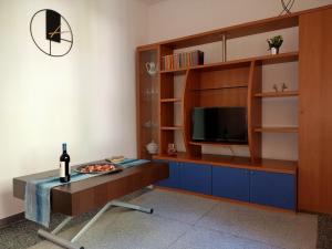 a living room with a tv and a table with a bottle of wine at Erika's Home in Milan