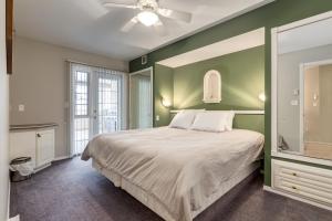 Un dormitorio con una cama y una pared verde. en Mountain View Villas with Fairmont Creek Vacation Rentals, en Fairmont Hot Springs
