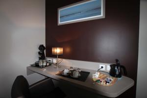 a desk with a computer on it with a window at Hôtel Le Cheval Blanc in Quend-Plage