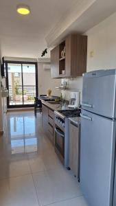 een keuken met een witte koelkast en een fornuis bij 3 Personas - Balcon, Wifi & Cafe in Santiago del Estero