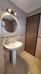 een badkamer met een wastafel en een spiegel bij 3 Personas - Balcon, Wifi & Cafe in Santiago del Estero +15 foto's