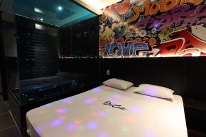a bedroom with a white bed with a painting on the wall at Motel Dolce in São Bernardo do Campo