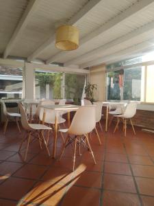 a dining room with white tables and chairs at La Casa de los Pájaros in Tanti
