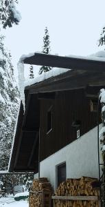 a building with a pile of wood in front of it at Bungalow direkt am See, mit eigenem Boot in Roding