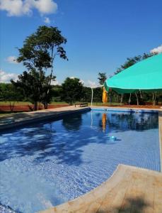 a large swimming pool with a green tent in the background at Los Lapachos Lodge in Puerto Libertad