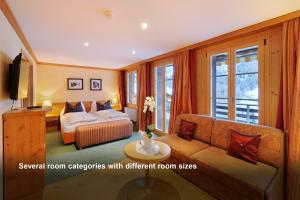 
a bedroom with a large bed and a large window at Hotel Kirchbühl Superior in Grindelwald
