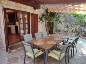 a wooden table and chairs in a patio at House Davor in Sutivan