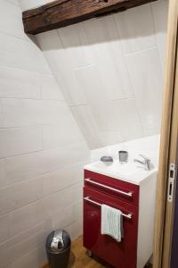 ein Badezimmer mit einem roten Schrank und einem Waschbecken in der Unterkunft la petite maison in Wintzenheim