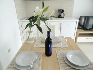 a table with plates and a bottle of wine on it at Apartment At the sea in Klek +64 photos