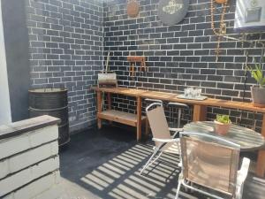 a patio with a table and chairs and a brick wall at Beach House SantaElena in Pisco