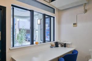 a window in a room with a counter and a blue chair at Kaikai House - Art, Design & Family in Shibuya in Tokyo
