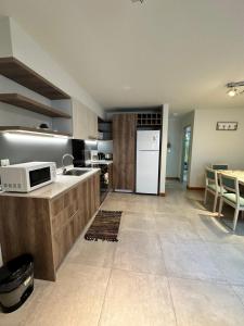 a kitchen with a white refrigerator and a table at Umain 18 SOL in San Martín de los Andes +10 photos