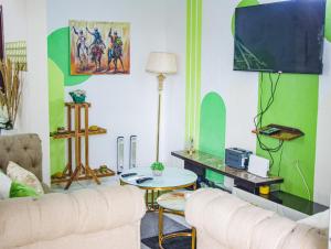 a living room with a couch and a table at Maxim Hous, Central au Rond point Maetur Bonamoussadi, Fibre Optique, Groupe électrogène, Forage, Parking, Netflix, Canal Sat, Balcon emmenagé in Douala