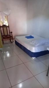 リバスにあるHostal Brisas del Ometepe Habitación 4のベッドルーム1室(ベッド1台、椅子付)