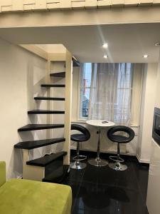 Eine Treppe in einem Zimmer mit zwei Hockern und einem Tisch in der Unterkunft Fashion street mini apartment in Budapest