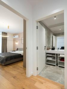 a bedroom with a bed and a sink in a room at Orange Luxury King bed Apartment, bussiness, leisure in One Cotroceni in Bucharest