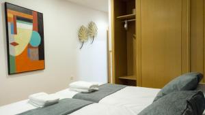 una camera da letto con un letto con asciugamani sopra di Apartamentos San Pedro Regalado a Valladolid