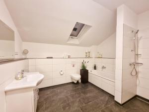 a white bathroom with a sink and a toilet at Neue Moderne FeWo Europa-Park & Rulantica in Ringsheim +36 photos