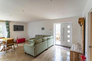a living room with a couch and a table at Ashenhurst, woodland lodge with hot tub for 4 in Oakamoor