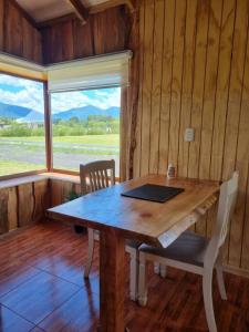 a wooden table in a room with a laptop on it at Cabaña Antü küyen Melipeuco in Melipeuco