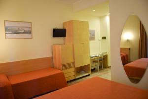 pokój z sypialnią z łóżkiem i lustrem w obiekcie Hotel Losanna w Mediolanie