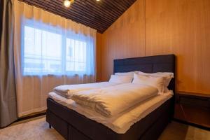 Un dormitorio con una cama grande con ventana. en Aurora Haven, en Tromsø